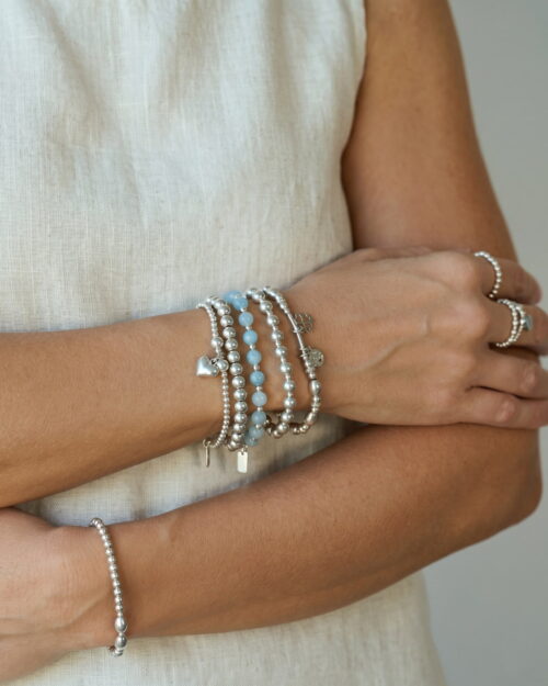 Pulsera RIVIERA de bolas de aguamarina natural y Plata de Ley 925 puesta y combinada con otras pulseras AULINE en la muñeca