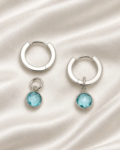 Pendientes Halo de aro redondo en plata de ley 925 con cristales azules colgantes, sobre tela satinada color crema