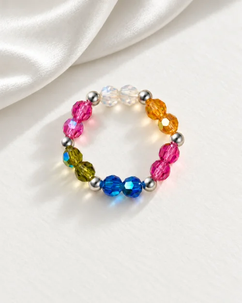 Anillo Prisma de cristales Preciosa® multicolor y bolas de plata de ley 925, sobre fondo color crema con tela satinada