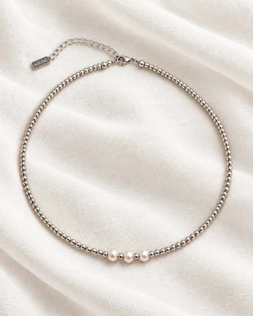 Collar Lua de bolas de plata de ley 925 con tres perlas naturales centrales, sobre tela satinada color crema