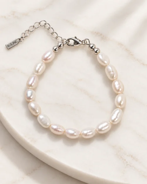 Pulsera Maia de perlas naturales ovaladas con cierre y alargador de plata de ley 925, sobre base de mármol color crema